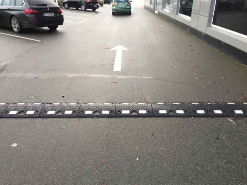 TDJ Vejbump 20 km/t sort med hvid refleks typegodkendt af vejdirektoratet. P-plads ved Brik i Holstebro. Trafikgummi.dk